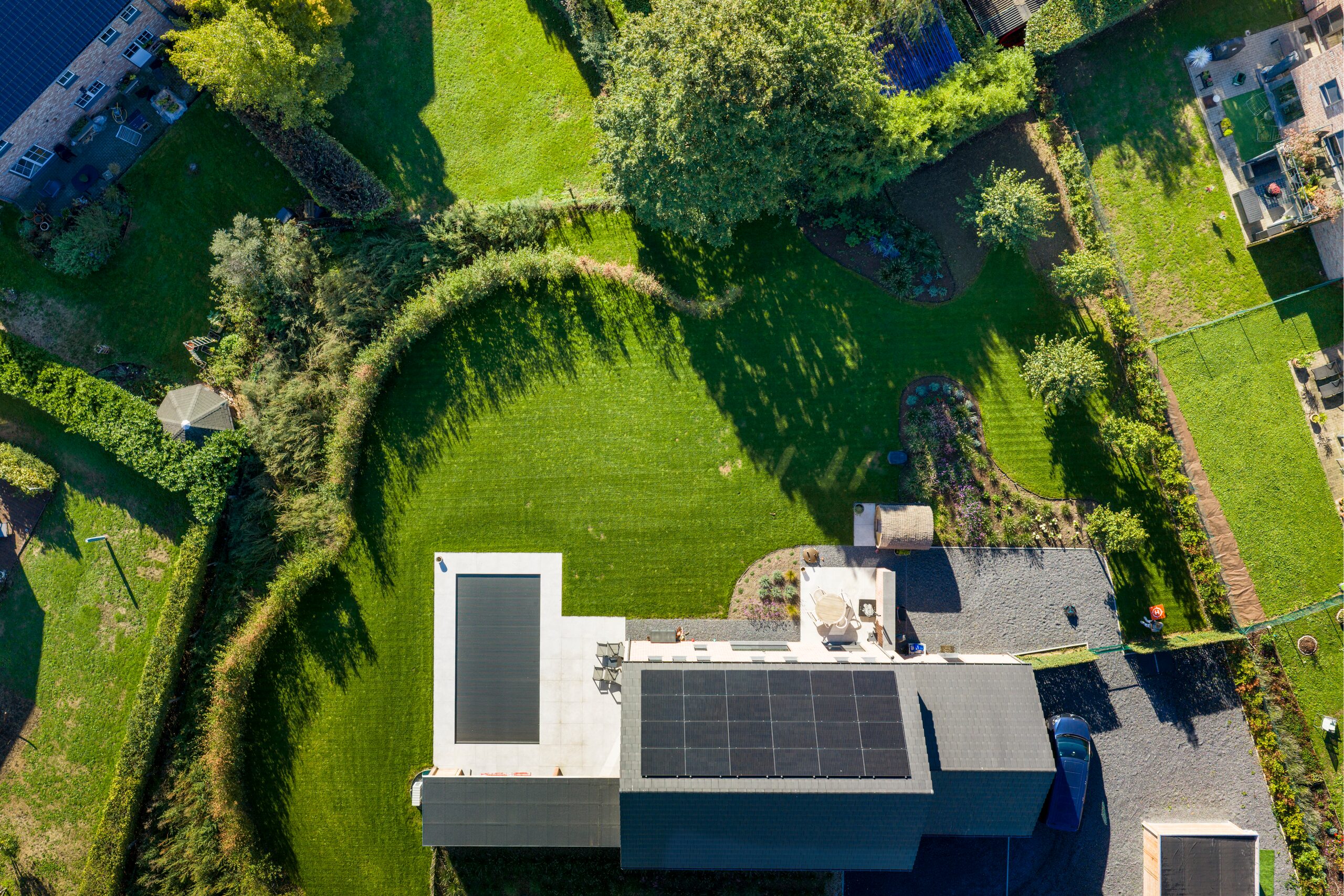 Vue aérienne d'un jardin de maison contemporaine bordé de haies aux formes arrondies