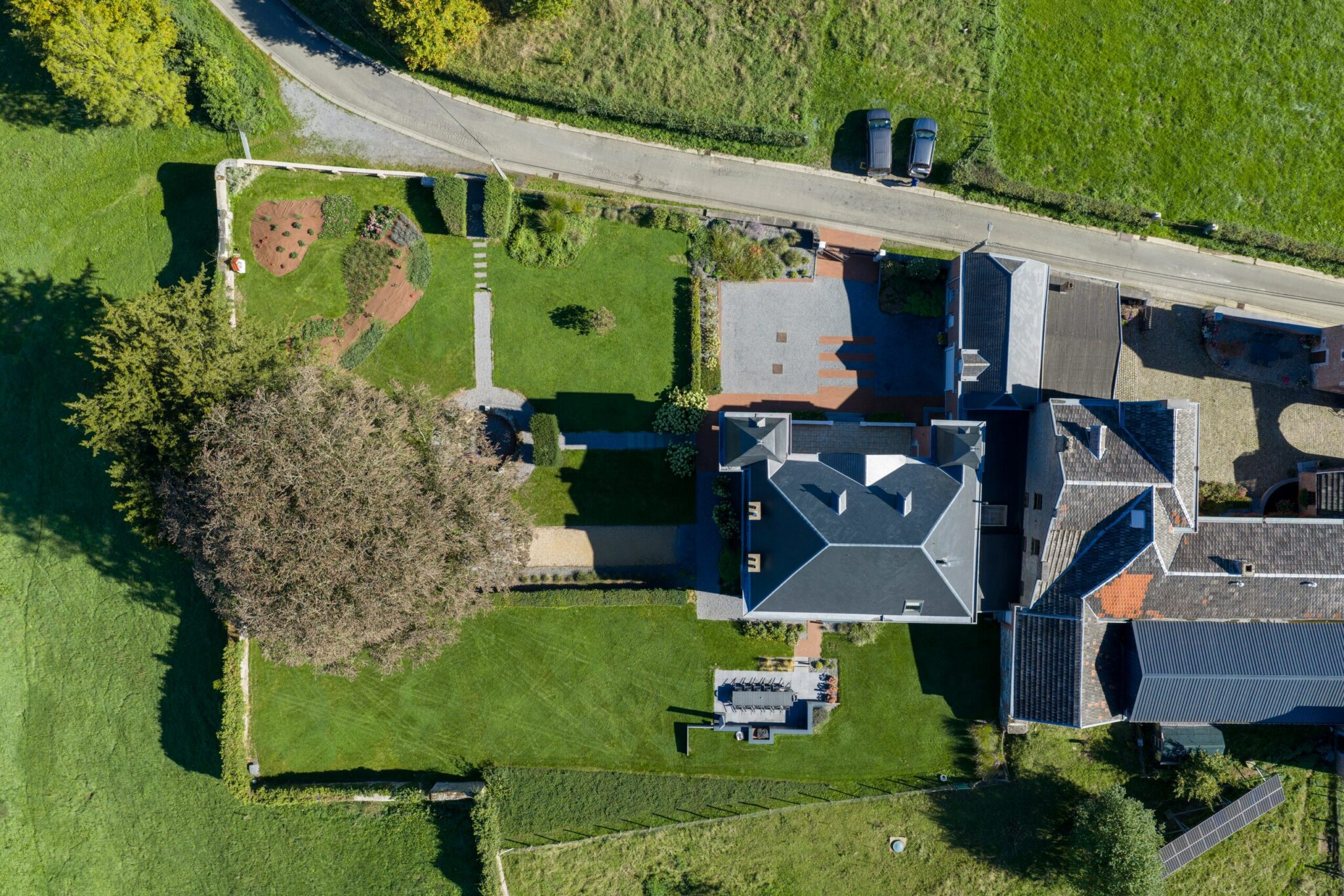 Vue aérienne d'un manoir et de son jardin clos de murs en pierre